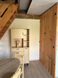 a kitchen with wooden cabinets and a table and chairs at Le gîte de la courte soupe in Éteignières +4 photos