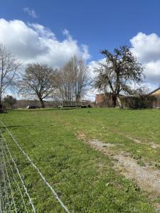 a fence in a field with trees in the background at Le gîte de la courte soupe in Éteignières