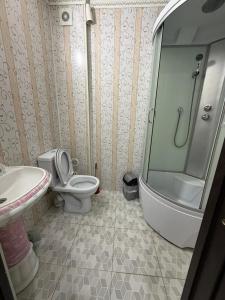 a bathroom with a shower and a toilet and a sink at Apple Hostel Cholpon Ata in Cholpon-Ata