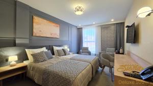 a hotel room with a bed and a desk at Hotel Siesta in Užice +36 photos