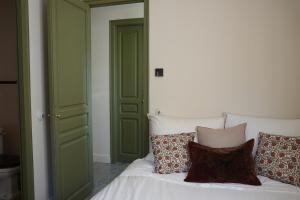 a bedroom with green doors and a bed with pillows at La Torre Retreat in Borredá