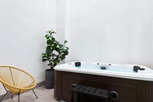 a bath tub with a chair and a plant at Alameda 1851 - Private jacuzzi in Seville