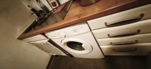 a washer and dryer in a kitchen under a counter at OneRoomStay in Delmenhorst