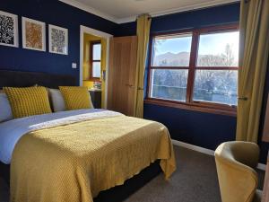 a bedroom with a bed with a yellow blanket and a window at Mizpah Bed & Breakfast near Ben Nevis Highlands in Roybridge +7 photos