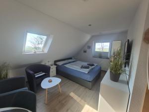 a small bedroom with a bed and a couch at Apartmenthaus Westerkoog in Hedwigenkoog