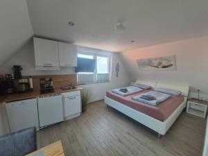 a small bedroom with a bed and a kitchen at Apartmenthaus Westerkoog in Hedwigenkoog