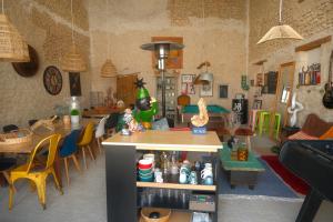 a living room with tables and chairs and a kitchen at La Norélie in Saint-Sulpice-de-Royan