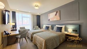 a hotel room with two beds and a desk at Hotel Siesta in Užice