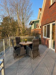 a patio with a table and chairs on a deck at Haus Seeschwalbe - Wohnung 07 in Spiekeroog