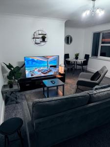 a living room with a couch and a flat screen tv at One bedroom Flat in Birmingham City Centre with free underground parking in Birmingham