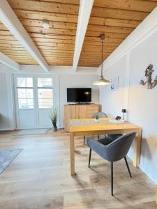 a dining room with a wooden table and a chair at Ferienwohnung Heimat auf Zeit Pellworm in Pellworm