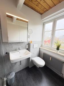 a bathroom with a sink and a toilet and a window at Ferienwohnung Heimat auf Zeit Pellworm in Pellworm +5 photos