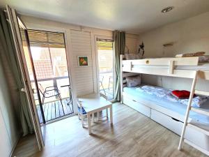 a bedroom with two bunk beds and a balcony at Blaue Dören in Langeoog