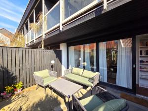 a patio with two chairs and a table on a balcony at Blaue Dören in Langeoog