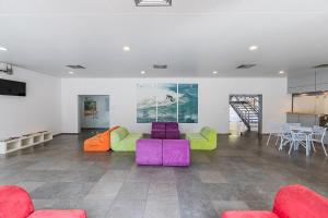 a living room with colorful furniture and a kitchen at Hi Espinho - Pousada de Juventude in Espinho