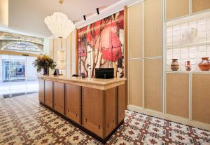 a lobby with a counter and a painting on the wall at H10 Raco del Pi Boutique hotel in Barcelona