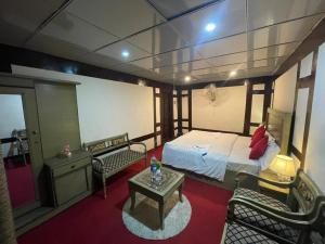 a bedroom with a bed and a table and chairs at Ringachan Guest House & Restaurant in Skardu