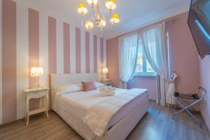 a bedroom with a bed and a chandelier at Les Suites Magnolia in Olbia