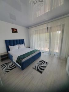 a bedroom with a bed and a large window at Constantin Rooms in Eforie Nord