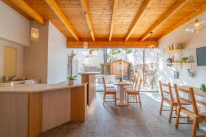 a kitchen with wooden ceilings and a table with chairs at Les Suites Magnolia in Olbia
