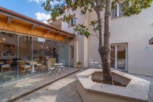a patio with a tree and a table and chairs at Les Suites Magnolia in Olbia