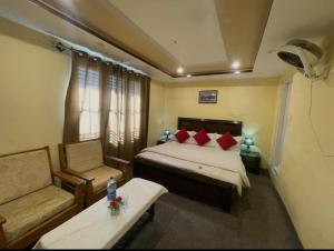 a hotel room with a bed and a chair at Ringachan Guest House & Restaurant in Skardu