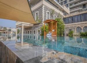 a building with a fountain in front of a building at Europa 1917 - Mehadrin Kosher suitable for Ultra-Orthodox guests in Tiberias