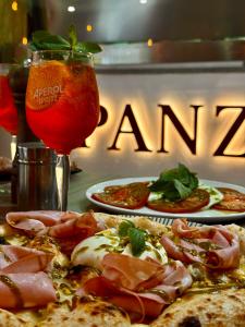 a table with two plates of pizza and a drink at Hotel Faranda Los Tilos, Ascend Hotel Collection in Santiago de Compostela