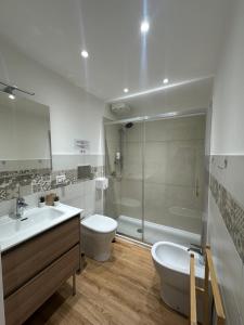 a bathroom with a sink and a toilet and a shower at Etna Vibes Home in Catania +34 photos