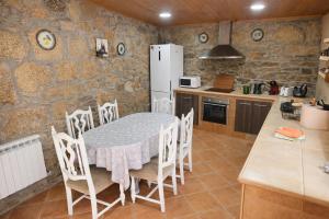 a kitchen with a table and chairs and a refrigerator at A Banda do Río in Vilagarcia de Arousa