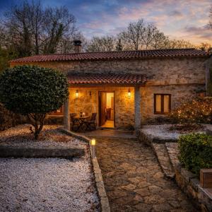 a stone house with a pathway leading to a door at A Banda do Río in Vilagarcia de Arousa