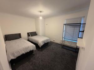 a bedroom with two beds and a window at Central Luton, Guest House, Contractor Friendly, Long Stays Welcome in Luton