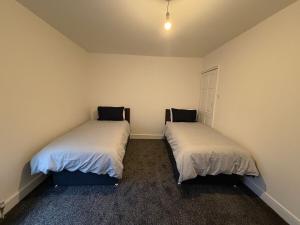 two beds in a small room withermottermottermottermott at Central Luton, Guest House, Contractor Friendly, Long Stays Welcome in Luton