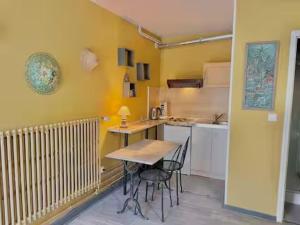 a small kitchen with a table and chairs in it at LA MONGEARDIERE in Ay