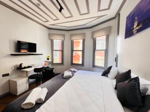 a large white bed in a room with windows at Rovigo Hotel in Istanbul