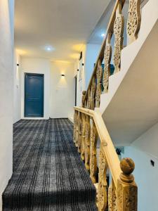 a hallway with a staircase with a blue door at Gulmarg serenity in Khor