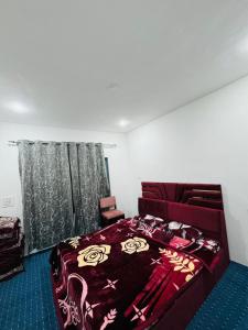 a bedroom with a bed with a red comforter at Gulmarg serenity in Khor