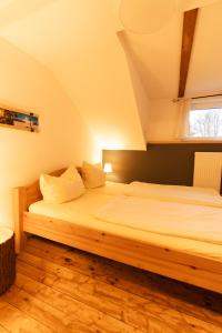 a bedroom with a wooden bed in a attic at Bullhead House in Warmensteinach