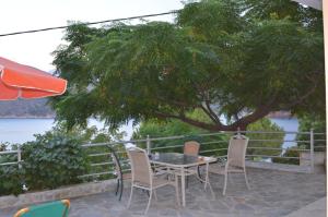 a patio with a table and chairs and a tree at Villa Platanaki in Kerveli