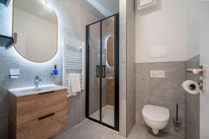 a bathroom with a shower and a toilet and a sink at Apartmán Sekvoja in Nová Baňa +21 photos