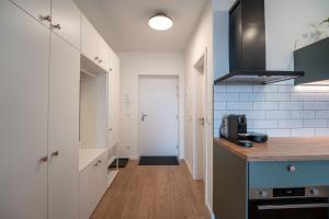 a kitchen with white cabinets and a wooden floor at Apartmán Sekvoja in Nová Baňa