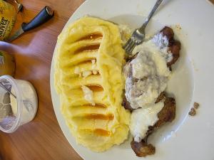a white plate with a waffle with ice cream at Casa LarisaAndrei in Bîrsău