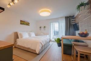 a bedroom with a bed and a table and a window at Apartmán Sekvoja in Nová Baňa