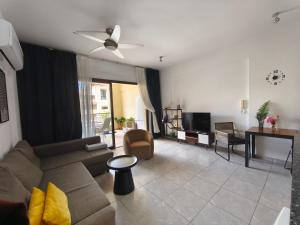 a living room with a couch and a tv at Queens gardens in Paphos