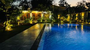 a swimming pool in front of a house at night at Aloria Sigiriya in Sigiriya
