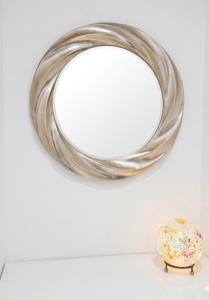 a round mirror on a wall next to a vase at Gemmina Sun in Vernazza