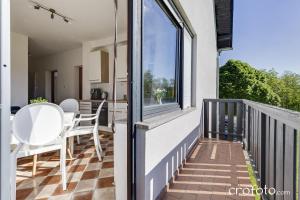 a balcony with white chairs and a table and a window at Apartments Villa Mavi in Plitvička Jezera +28 photos