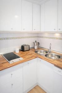 a white kitchen with a sink and a counter at APN Hatabin in Granada