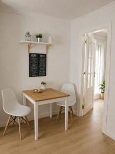 a dining room with a table and white chairs at APN Hatabin in Granada