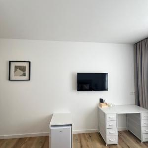 a white room with a desk and a tv on a wall at Le onze in Namur +34 photos